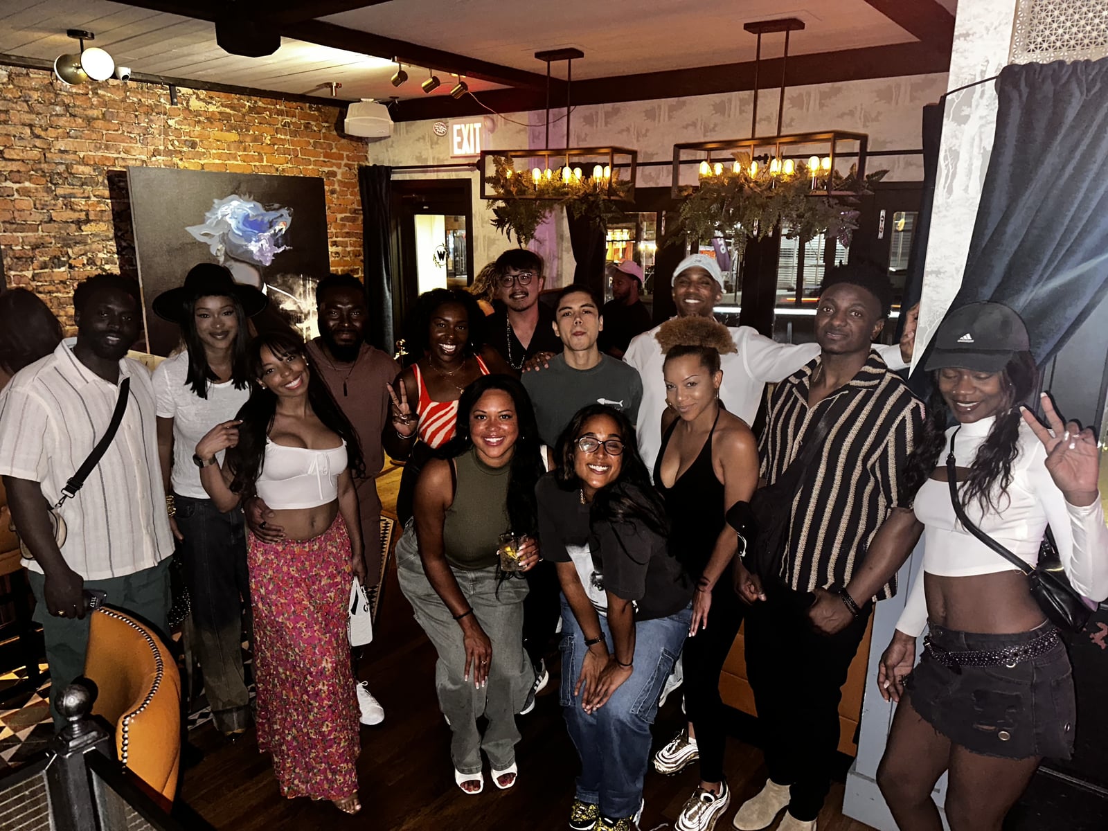 The full Woodlot room gathers for a group photo under the chandeliers after La Phiesa's June set.