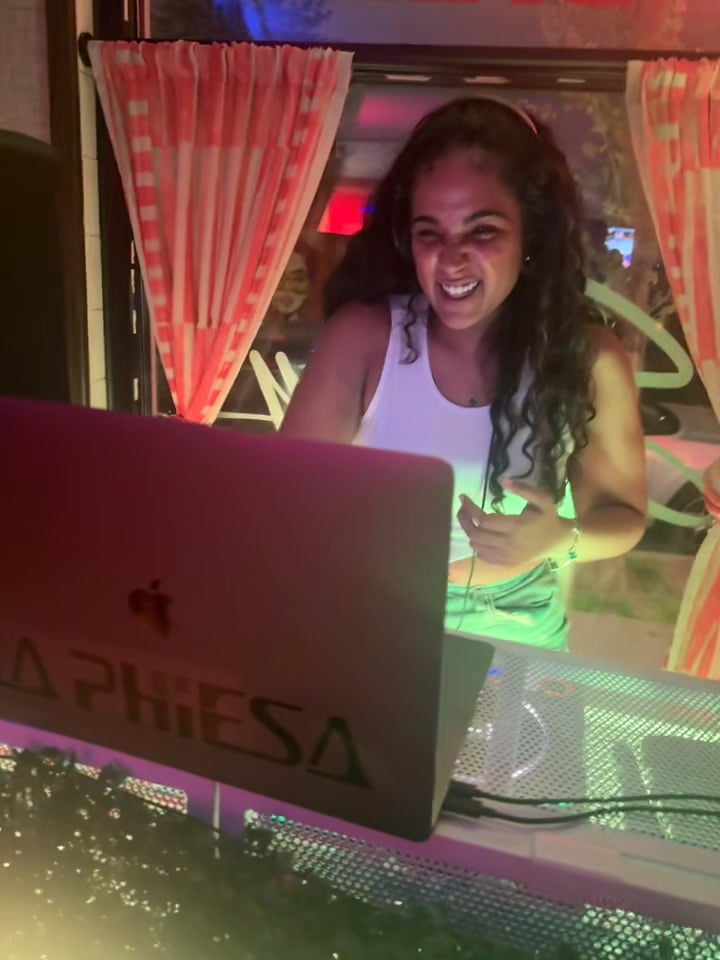 A big mid-set laugh from La Phiesa at Saucey, her branded laptop lit up across the front of the booth.