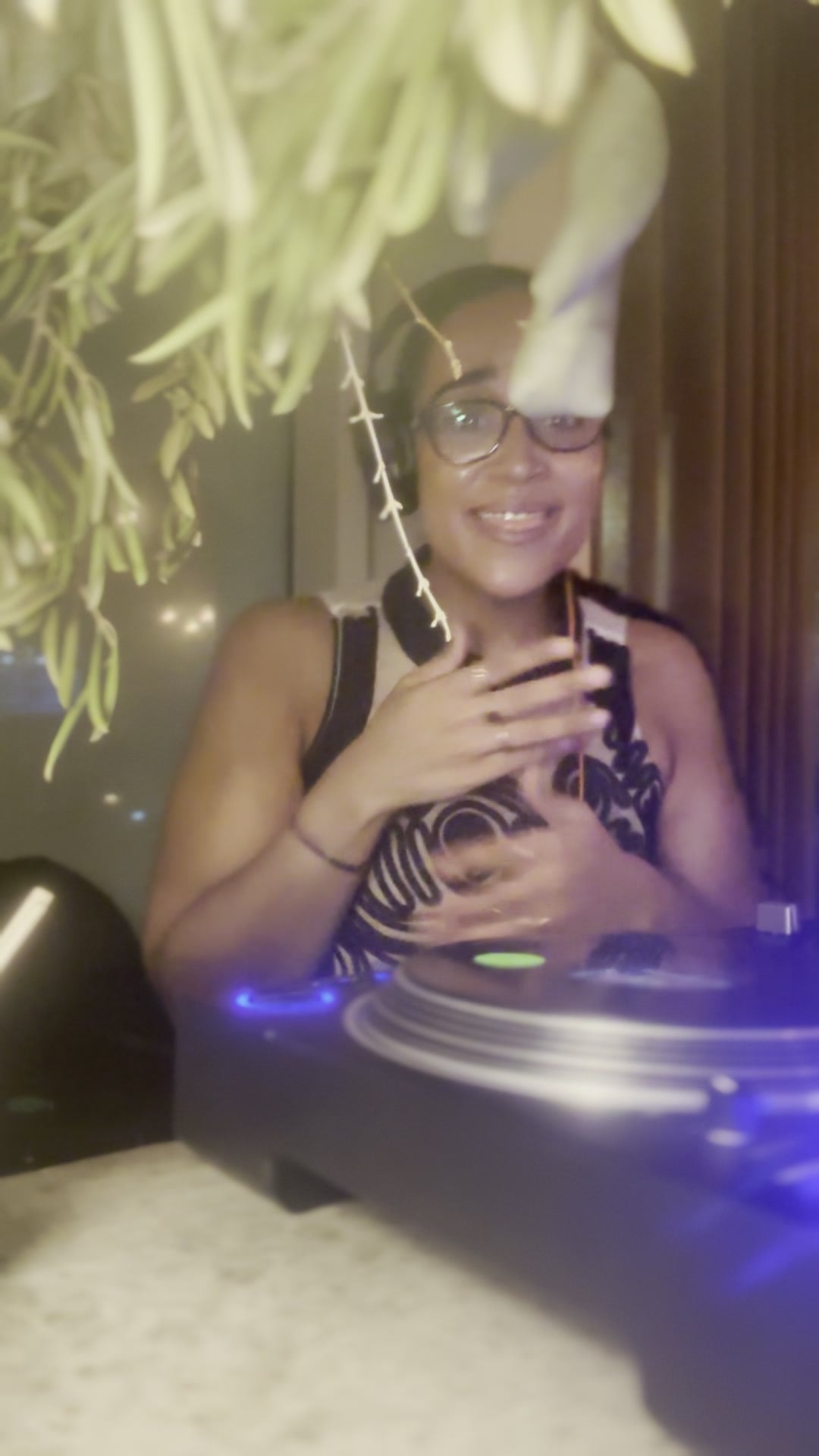 La Phiesa grinning behind the decks at PAX, headphones on and vines trailing over the booth