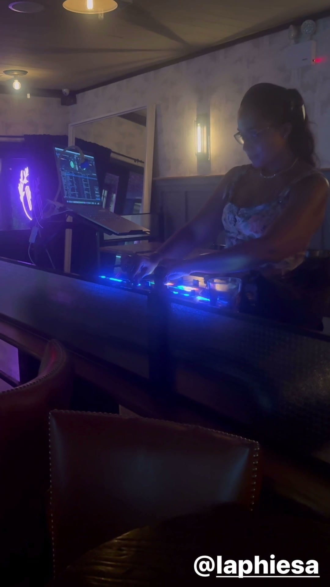 La Phiesa cueing the next track at Woodlot, her track library lit up on the laptop screen beside the decks.