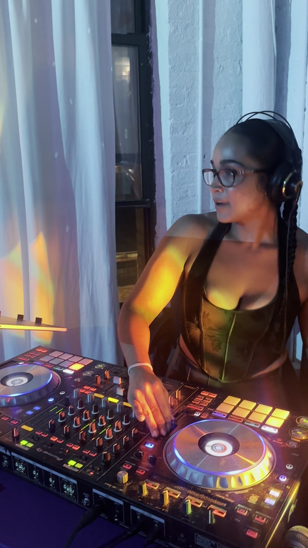 La Phiesa leaning into the jog wheel at Hussle Lab, the Pioneer setup lit orange against the loft's white brick.