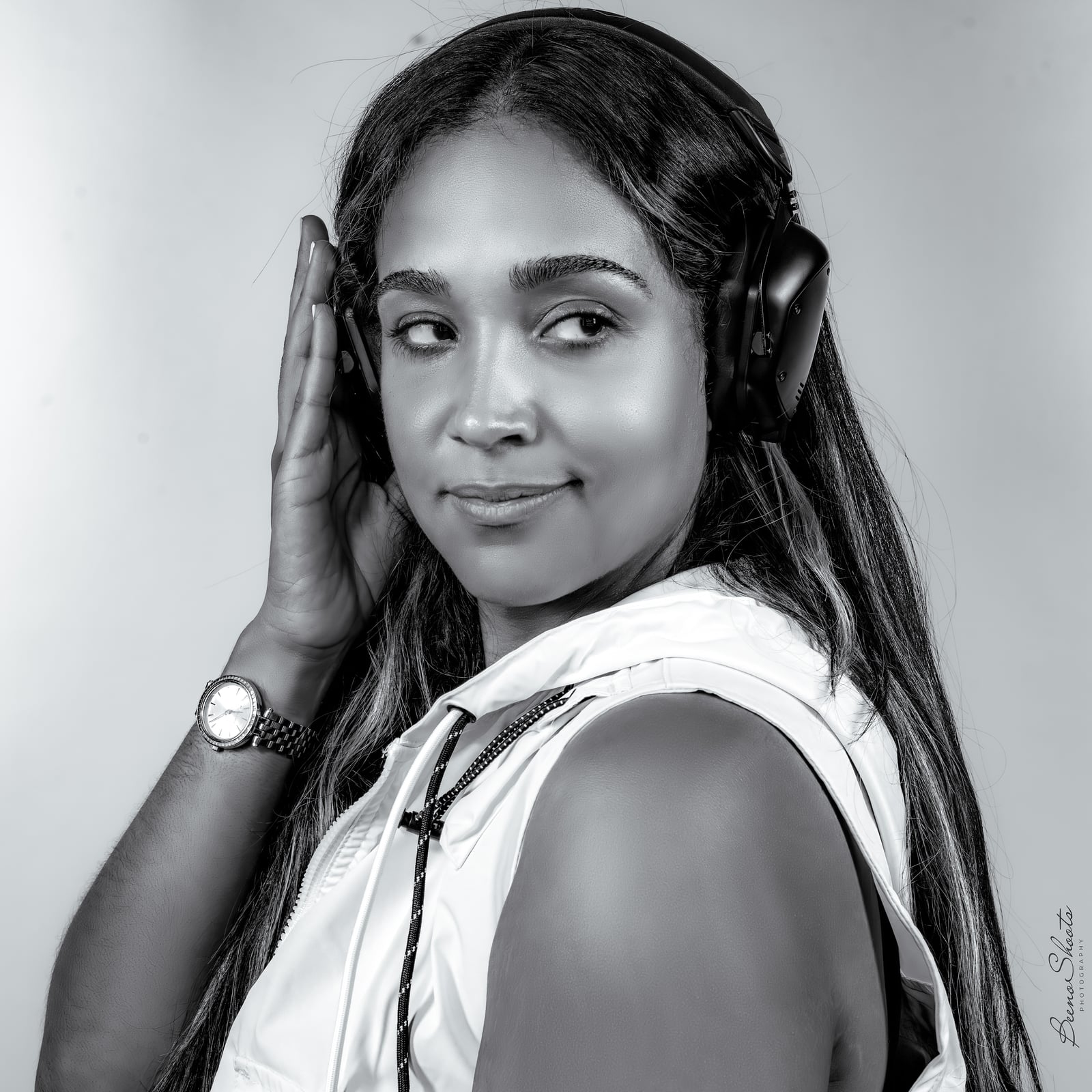 Black-and-white side-profile portrait of La Phiesa, hand resting on her headphones
